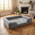 Gray raised-edge orthopaedic dog bed with plush cushion and thick bolstered sides, no dog present.