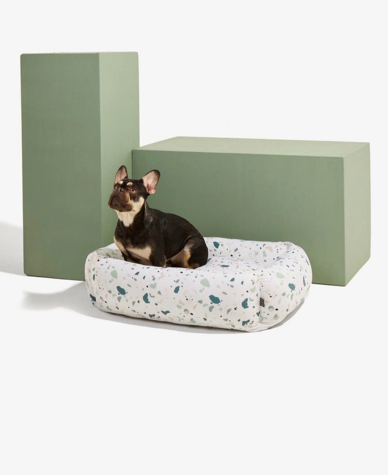 Orthopaedic dog bed with green terrazzo speckle fabric and raised side bolsters
