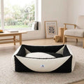 Orthopaedic dog bed with black sides and white pressure-relief bolster in a low oval shape